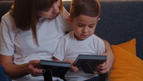 Woman Her Little Son Sitting Couch Looking Photographs  Strokes His Hair