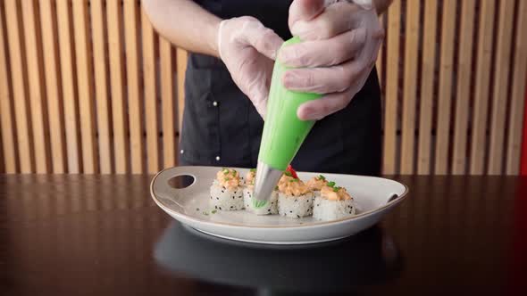 Chef Prepares Sushi Roll for Serving in a Restaurant