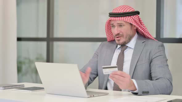 Middle Aged Arab Businessman making Online Payment Failure on Laptop in Office