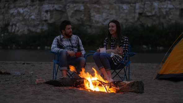 Travel and Love Concept. Young Lovely Couple Near Fireplace on Camp