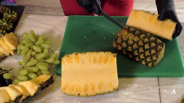 Female Hands Cutting with Knife Ripe Pineapple to Slice
