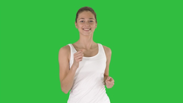 Beautiful sporty woman running on a Green Screen, Chroma Key.