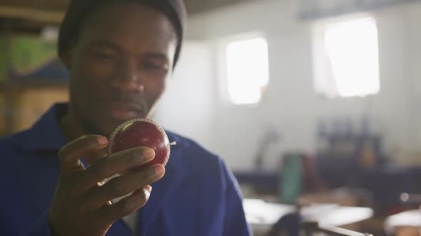 Mixed race man holding hand-made ball in factory