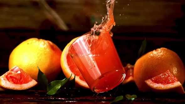 Super Slow Motion Glass with Grapefruit Juice Falls on the Table