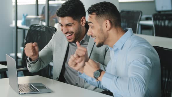 Cheery Men Celebrate Unbelievable Notice Read on Laptop