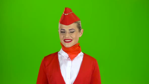 Stewardess in a Red Suit Winks a Slight Flirt Sends an Air Kiss. Green Screen