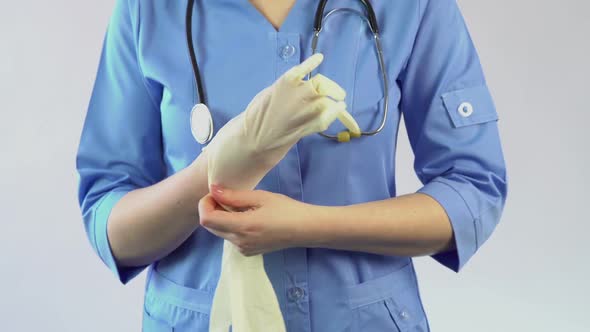 Gastroenterologist Putting on Rubber Gloves and Preparing for Patient Inspection
