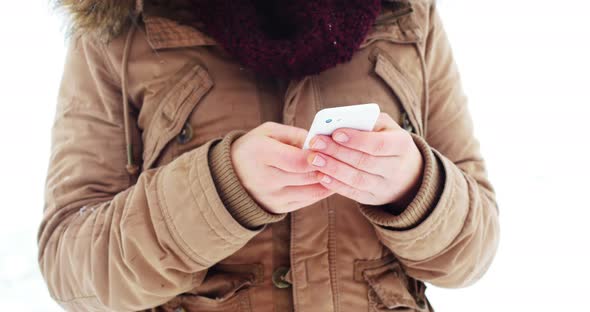 Woman in fur jacket using mobile phone