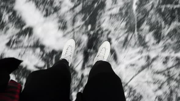 Ice skating on frozen lake - legs top view