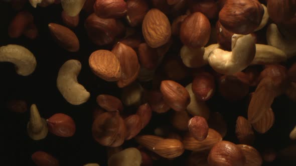 A Group Of Nuts Is Falling In The Air In High Speed On Black Background A Top View