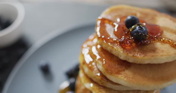 Video of pancakes on plate seen from above on wooden background