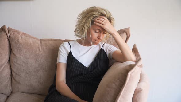 Beautiful Sad Middle Woman Sitting on Couch at Home