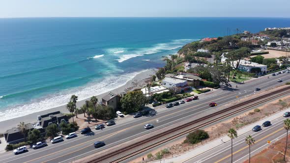 Drone shot flying over a road leading to a beautiful beach in Encinitas, California.