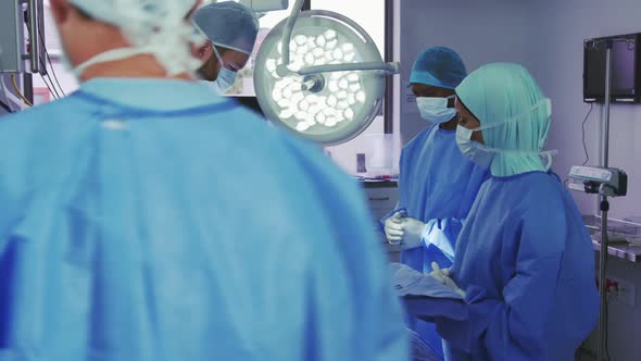 Side view of Caucasian surgeon performing operation in operation theater