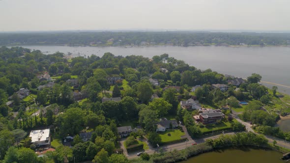 Aerial Pan of a Small Long Island Town Amongst Trees and Near Water