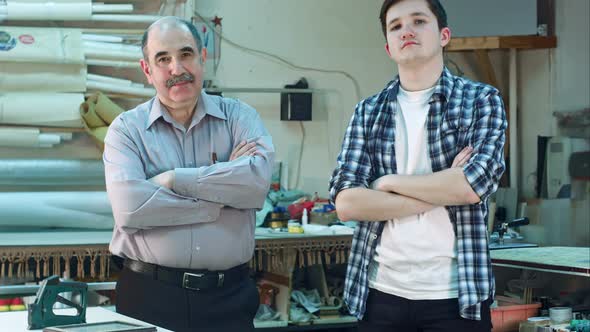 Portrait of Two Workers, Standing in Workshop and Looking at Camera Seriously