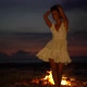 Charming Woman Joyfully Dancing in Front of Fireplace on Sandy Seaside Mysterious Party Evening - VideoHive Item for Sale