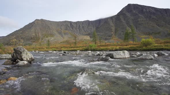 A Fast Cold River Flows Through Fields and Mountains