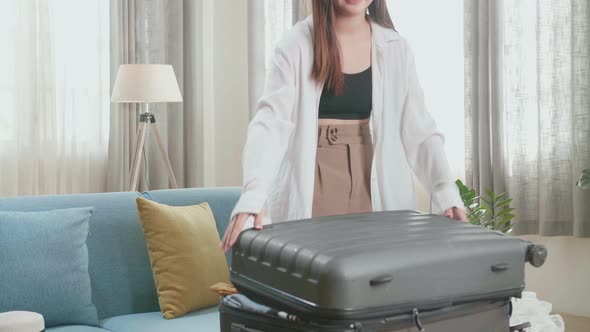 Asian Woman Preparing For Travel Adventure, Packing Clothes Into Suitcase, Getting Ready For Trip