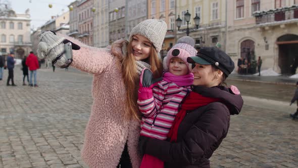 Lesbian Couple Tourists with Adoption Child Girl Taking Selfie or Making Video Chat on City Street