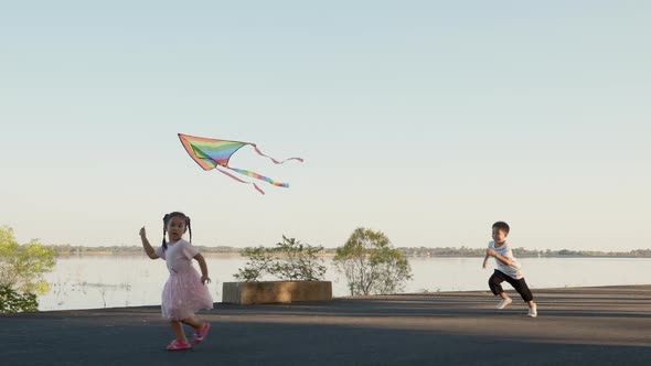 Asian two brothers happy children boy and girl with a kite running to fly