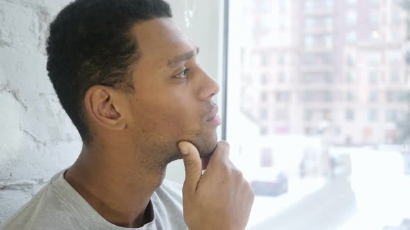 Close Up of Pensive AfroAmerican Young Man Thinking Brainstorming