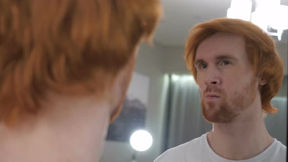 Confident Redhead Man Looking at Himself in Mirror