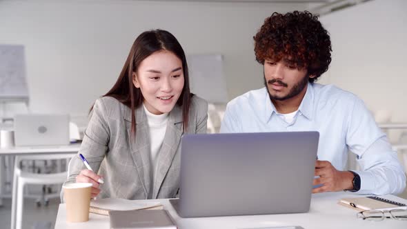 Two Creative Workers Discussing Online Startup Project Looking at Laptop Screen