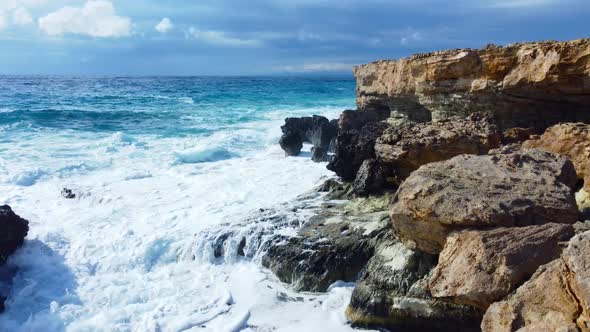 Aerial View of Waves Break on Rocks in a Blue Ocean Sea Waves on Beautiful Beach Bird's Eye View of