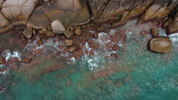 Aerial Top View  Footage By Drone of Ocean Blue Waves Break on High Cliff of a Rocky Mountain