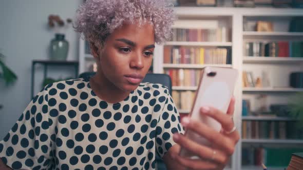 Joyful Woman Excitedly Looks at Phone Waiting for Message with Good News