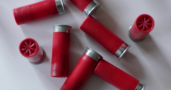 Shotgun shells scattered on white surface