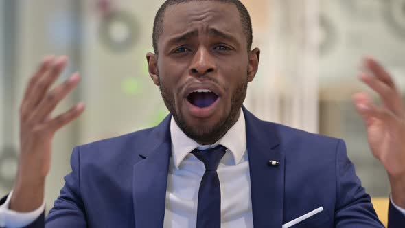 Portrait of Disappointed African Businessman Reacting To Loss 