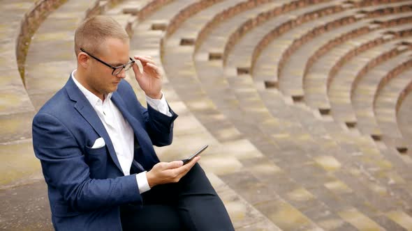 Handsome Young Entrepreneur Using Smart Phone Tablet