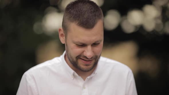 Smiling Bearded Dark-haired Young Man Standing Outdoors