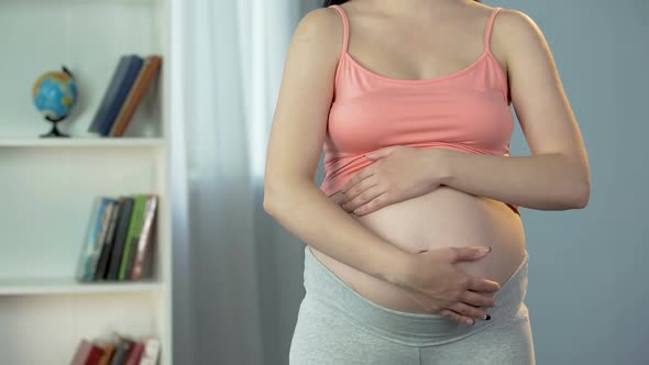 Hands of Pregnant Woman Touching and Rubbing Belly With Love, Expecting Baby