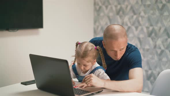 Little Daughter Sits on Her Dad's Lap