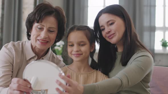 Beautiful Multigenerational Women Looking In Hand Mirror