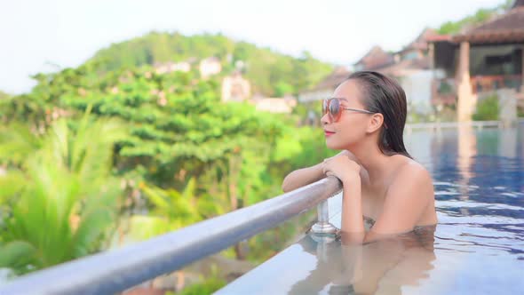 Young asian woman enjoy around outdoor swimming pool for leisure