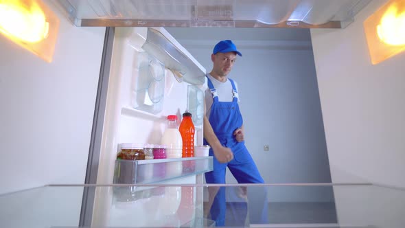 the refrigerator repairman is dancing an erotic dance. View from inside .