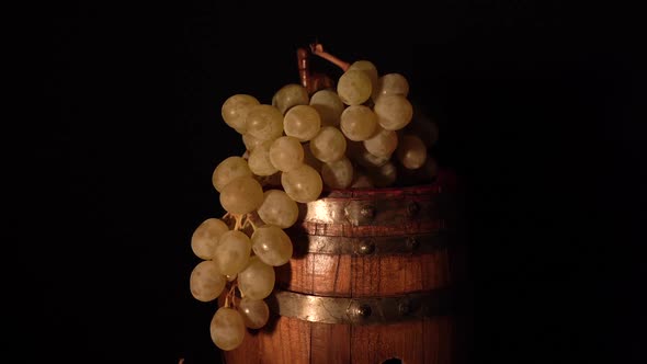 A bit closer view and backward rotating wine barrel with grape.