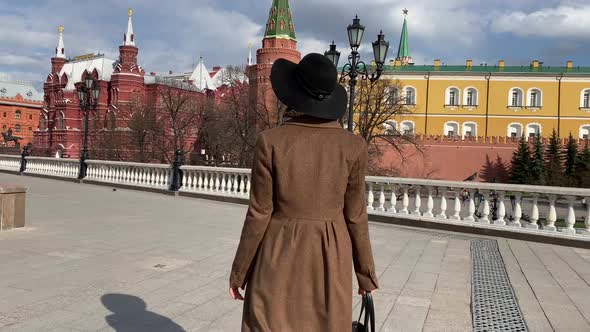 Elegant woman in hat walking on Red Square near Historical Museum, Kremlin, Red Square Moscow Russia