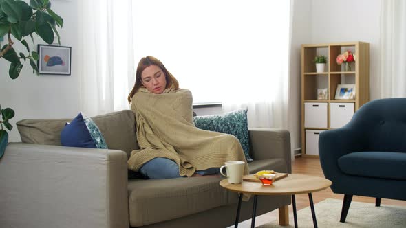 Sick Woman in Scarf Wrapping Into Blanket at Home