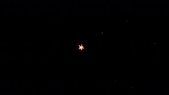 Man Shooting Bright Exploding Fireworks Lights on Black Background on His Phone Closeup Salute