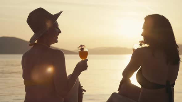 Females on Vacation By the Sea Relaxing and Drinking Cocktails