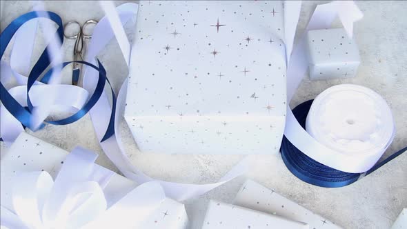 Woman ties a ribbon bow on a wrapped present