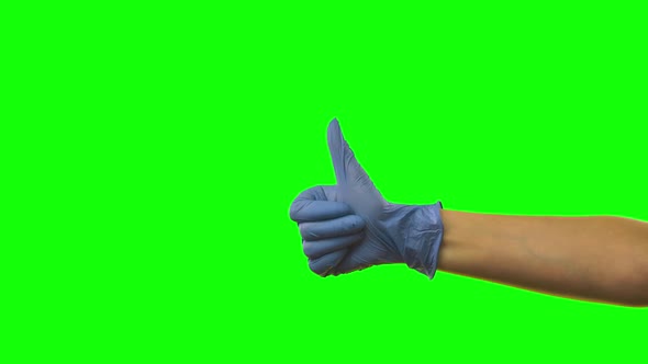 Doctors Female Hand in Blue Glove Is Holding Thumb Up Making Gestures Like. Green Screen. Close Up