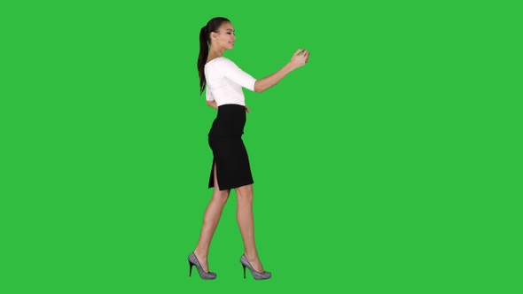 Pretty girl taking a selfie and walking on a Green Screen