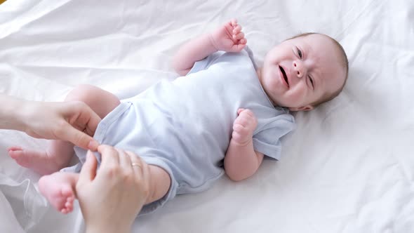 Mother Changes Diapers to Her Newborn Baby Little Boy on Changing Table in Clean Dry Nappy Mom