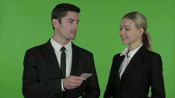 Male Professional Giving Dollar To Happy Female Professional, Chroma Key